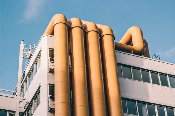 Yellow pipes on a building signifying data pipelines